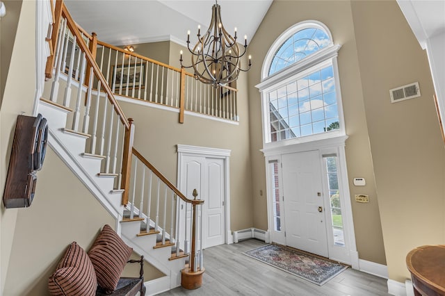 17 Pheasant Run Ln, Dix Hills, NY 11746 - entryway featuring high vaulted ceiling, a chandelier, wood finished floors, stairs, and a baseboard radiator