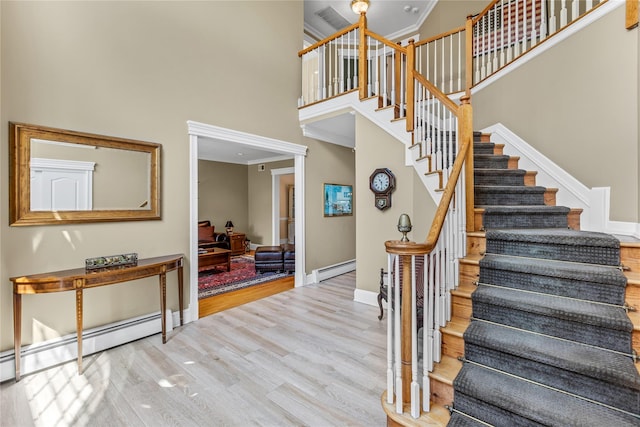 17 Pheasant Run Ln, Dix Hills, NY 11746 - staircase with a baseboard radiator, a high ceiling, wood finished floors, and crown molding