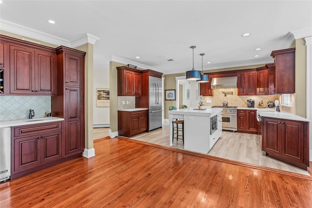 17 Pheasant Run Ln, Dix Hills, NY 11746 - kitchen featuring high quality appliances, wall chimney exhaust hood, reddish brown cabinets, light wood finished floors, and a kitchen island