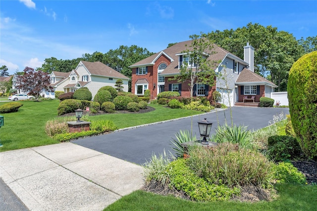 17 Pheasant Run Ln, Dix Hills, NY 11746 - view of front of home with asphalt driveway, a garage, brick siding, a front yard, and a chimney