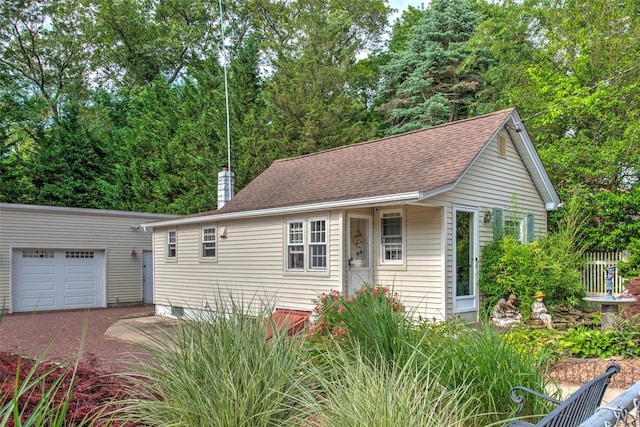 62 Port Washington Rd, Sound Beach, NY 11789 - view of front facade with a garage, a chimney, an outdoor structure, and a shingled roof