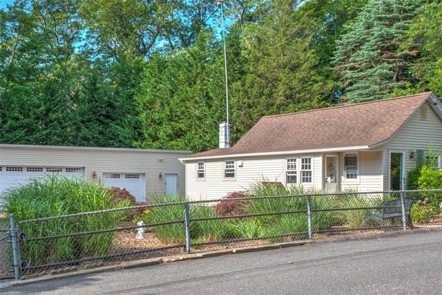 62 Port Washington Rd, Sound Beach, NY 11789 - view of front of house featuring a fenced front yard, a chimney, a garage, and roof with shingles
