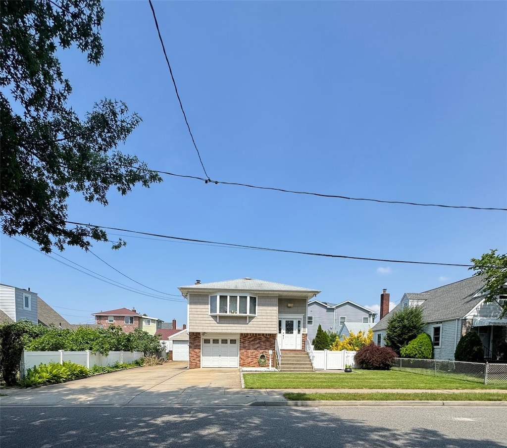 14 Edwards Pl, Valley Stream, NY 11580 - split foyer home featuring concrete driveway, an attached garage, and a residential view