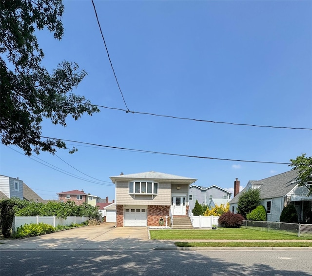 14 Edwards Pl, Valley Stream, NY 11580 - split foyer home featuring concrete driveway, an attached garage, and a residential view