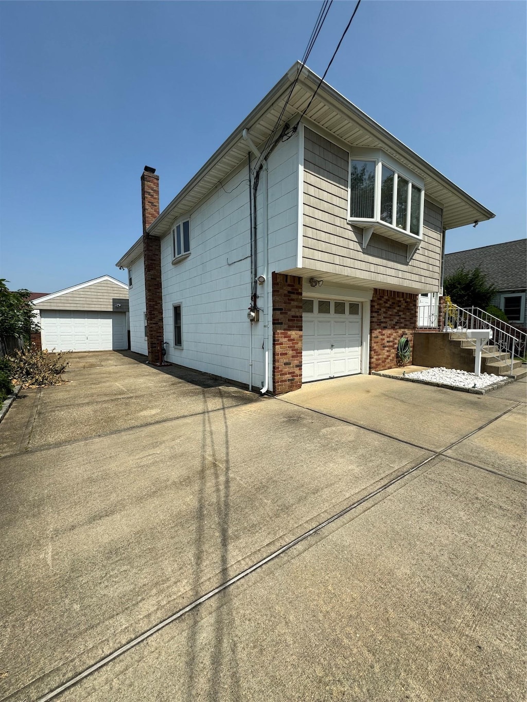 14 Edwards Pl, Valley Stream, NY 11580 - view of side of property with a chimney, brick siding, and a garage