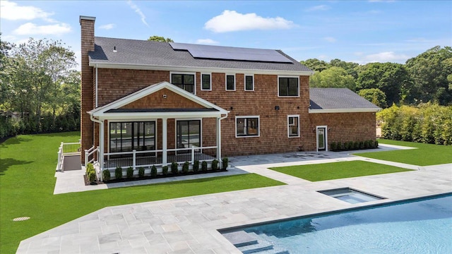 128 Sandy Hollow Rd, Southampton, NY 11968 - back of property with a chimney, a shingled roof, solar panels, a patio, and a yard