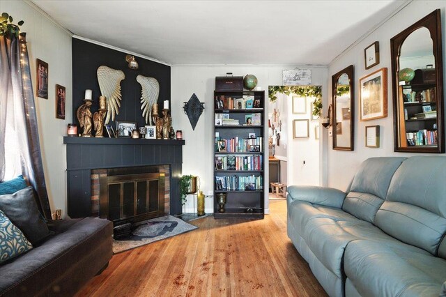209 Venetian Blvd, Lindenhurst, NY 11757 - living area featuring wood finished floors, a brick fireplace, and crown molding