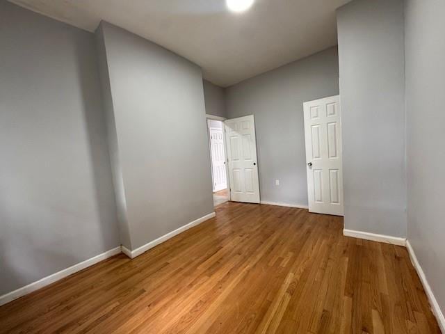 10326 171st St, Jamaica, NY 11433 - unfurnished bedroom featuring baseboards and light wood finished floors