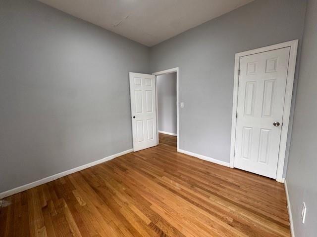 10326 171st St, Jamaica, NY 11433 - unfurnished bedroom with wood finished floors and baseboards