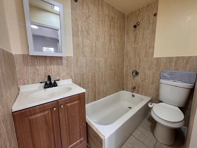 10326 171st St, Jamaica, NY 11433 - bathroom with tile walls, vanity,  shower combination, and tile patterned floors