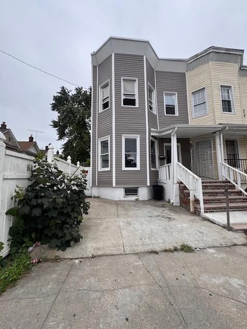 10326 171st St, Jamaica, NY 11433 - townhome / multi-family property with a porch