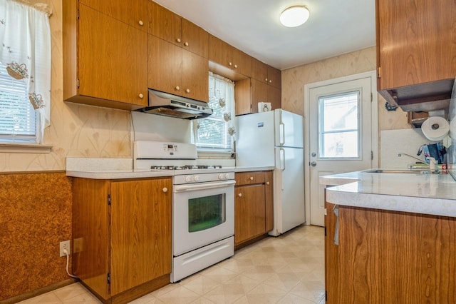 66 Gates Ave, Valley Stream, NY 11580 - kitchen featuring under cabinet range hood, white appliances, healthy amount of natural light, light countertops, and wallpapered walls