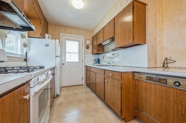 66 Gates Ave, Valley Stream, NY 11580 - kitchen featuring paneled dishwasher, ventilation hood, light countertops, brown cabinets, and backsplash