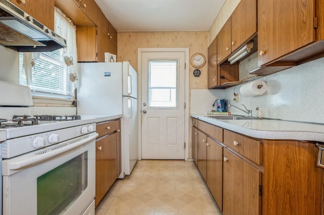66 Gates Ave, Valley Stream, NY 11580 - kitchen with white appliances, extractor fan, light countertops, backsplash, and brown cabinetry