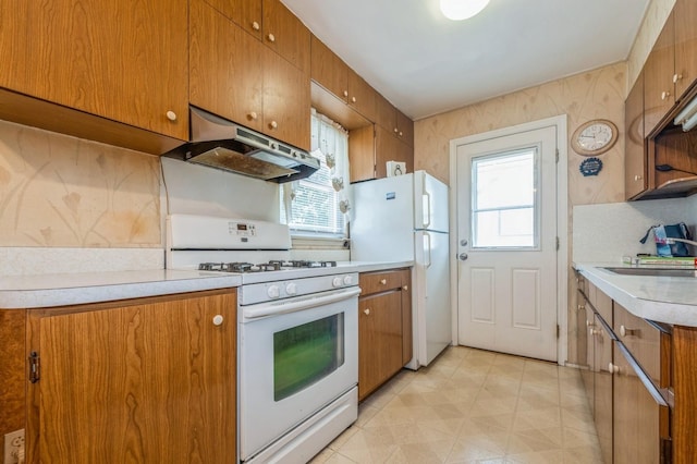 66 Gates Ave, Valley Stream, NY 11580 - kitchen with white appliances, under cabinet range hood, and brown cabinets