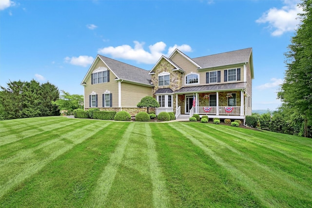36 Ballymeade Rd, Hopewell Junction, NY 12533 - view of front of home featuring a porch, a front yard, a standing seam roof, a metal roof, and stone siding