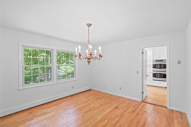 21 Kipp St, Chappaqua, NY 10514 - empty room with a baseboard heating unit, a chandelier, and light wood-type flooring