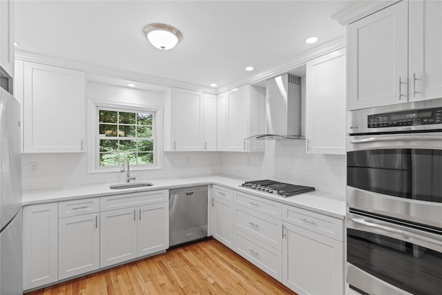 21 Kipp St, Chappaqua, NY 10514 - kitchen featuring appliances with stainless steel finishes, wall chimney range hood, light countertops, white cabinets, and backsplash