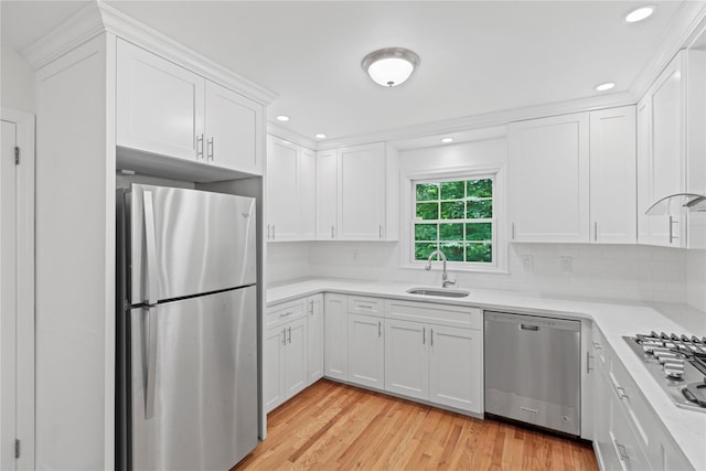 21 Kipp St, Chappaqua, NY 10514 - kitchen featuring stainless steel appliances, light countertops, white cabinetry, light wood-style floors, and decorative backsplash