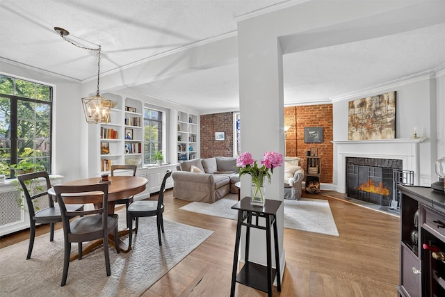 20 N Broadway Unit O-373, White Plains, NY 10601 - dining space with ornamental molding, a tiled fireplace, a textured ceiling, wood finished floors, and built in shelves
