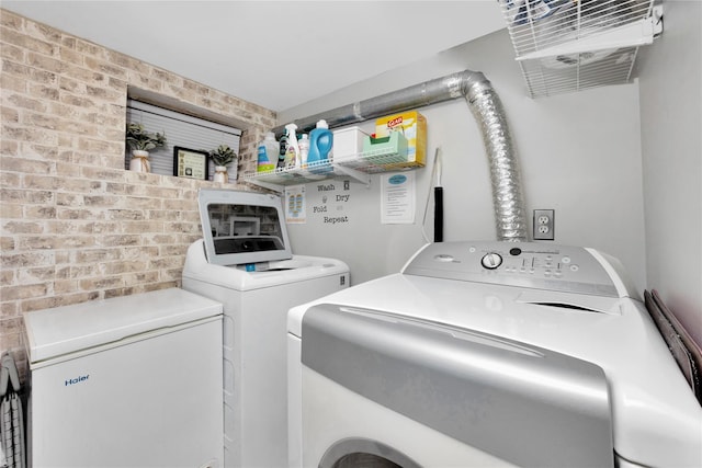12311 115th Ave, South Ozone Park, NY 11420 - laundry room featuring washing machine and dryer and brick wall