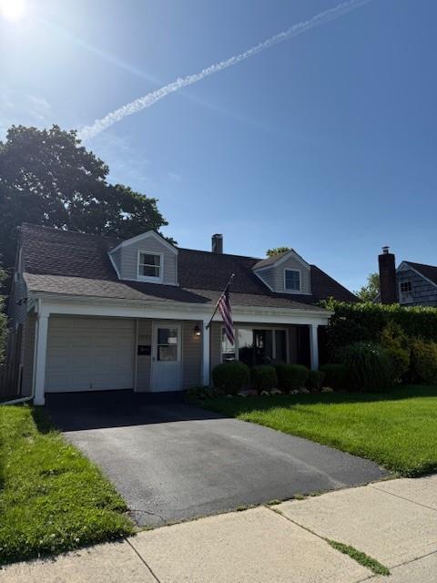 2691 Evans Rd, Oceanside, NY 11572 - view of front of house featuring a garage, a front lawn, and asphalt driveway