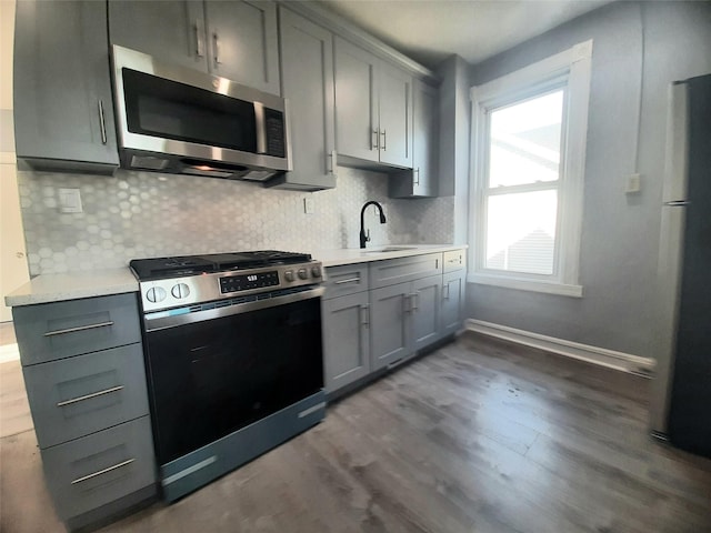 34 High St, Poughkeepsie, NY 12601 - kitchen featuring stainless steel appliances, gray cabinets, light countertops, dark wood-style flooring, and backsplash