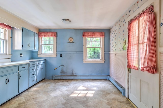 2 Shore Rd, East Setauket, NY 11733 - kitchen featuring a baseboard radiator, plenty of natural light, blue cabinets, stone finish floors, and ornamental molding