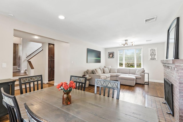 8 Walnut Rd, East Rockaway, NY 11518 - dining area with stairway, a fireplace, recessed lighting, wood finished floors, and a chandelier