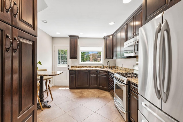 8 Walnut Rd, East Rockaway, NY 11518 - kitchen with appliances with stainless steel finishes, dark brown cabinets, light stone counters, recessed lighting, and light tile patterned flooring