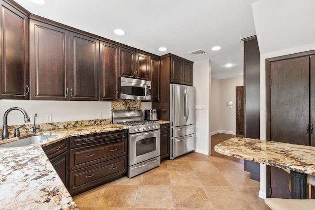 8 Walnut Rd, East Rockaway, NY 11518 - kitchen featuring appliances with stainless steel finishes, light stone counters, dark brown cabinets, and recessed lighting