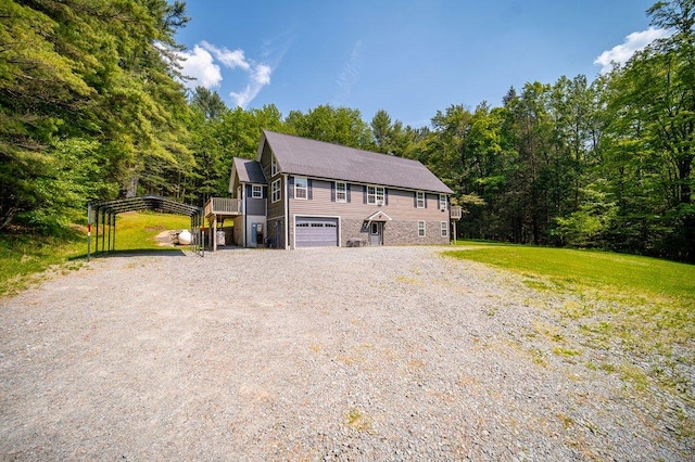 55 Townsend Rd, Liberty, NY 12754 - view of front of house with gravel driveway, a detached carport, an attached garage, and a front lawn
