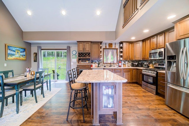 55 Townsend Rd, Liberty, NY 12754 - kitchen featuring appliances with stainless steel finishes, open shelves, backsplash, a kitchen breakfast bar, and brown cabinets