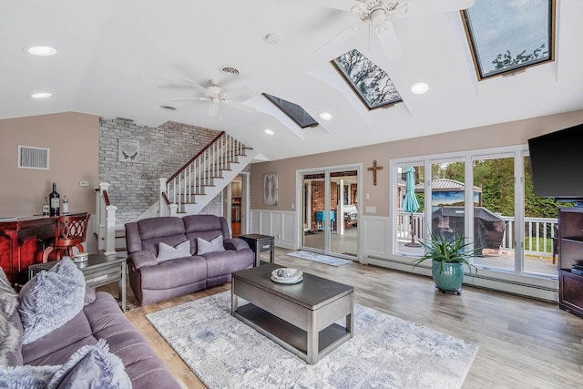 3 Stark Dr, Center Moriches, NY 11934 - living room with a ceiling fan, lofted ceiling, a skylight, wood finished floors, and stairs