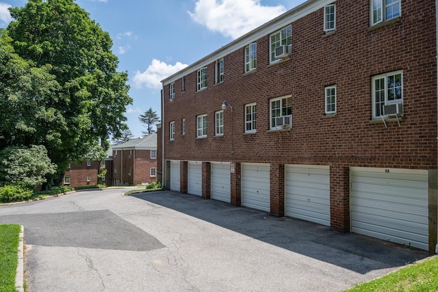 53 Nathan Hale Dr Unit 7A, Huntington, NY 11743 - view of building exterior featuring a garage, driveway, and cooling unit
