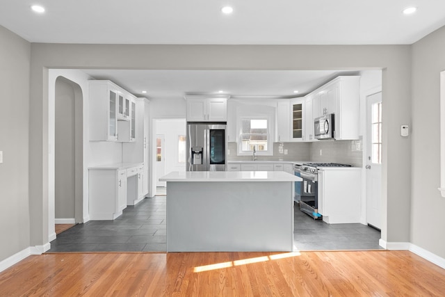 126 Lutz Dr, Valley Stream, NY 11580 - kitchen with appliances with stainless steel finishes, light wood-style flooring, light countertops, glass insert cabinets, and recessed lighting