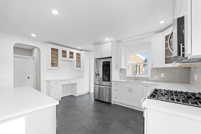 126 Lutz Dr, Valley Stream, NY 11580 - kitchen with stainless steel appliances, decorative backsplash, arched walkways, white cabinets, and recessed lighting