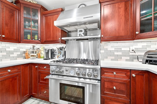 168 Dunwoodie St, Yonkers, NY 10704 - kitchen featuring high end stainless steel range, exhaust hood, decorative backsplash, light countertops, and glass insert cabinets