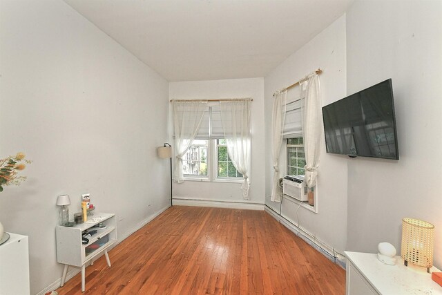 1244 Jefferson Ave, Brooklyn, NY 11221 - living area with wood finished floors, baseboard heating, and cooling unit