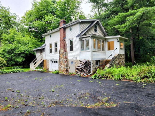 13SLake Drive, Patterson, NY 12563 - view of front of property featuring stairway, a chimney, asphalt driveway, and a garage