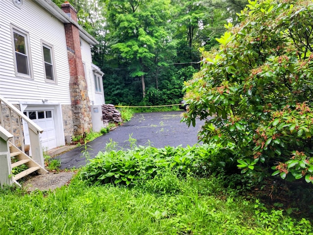 13SLake Drive, Patterson, NY 12563 - view of property exterior featuring driveway, a chimney, and an attached garage