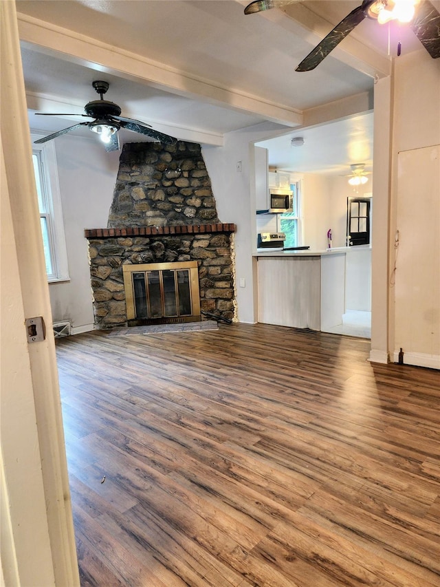 13SLake Drive, Patterson, NY 12563 - unfurnished living room featuring a ceiling fan, beamed ceiling, wood finished floors, and a stone fireplace