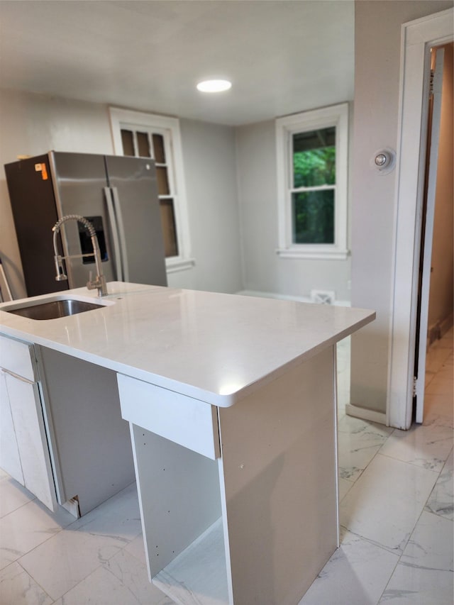 13SLake Drive, Patterson, NY 12563 - kitchen featuring stainless steel refrigerator with ice dispenser, light marble finish floors, a center island with sink, and light countertops