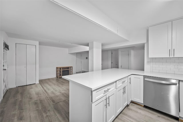 1440 Boston Post Unit 8K, Larchmont, NY 10543 - kitchen with stainless steel dishwasher, light countertops, light wood-type flooring, white cabinets, and a peninsula