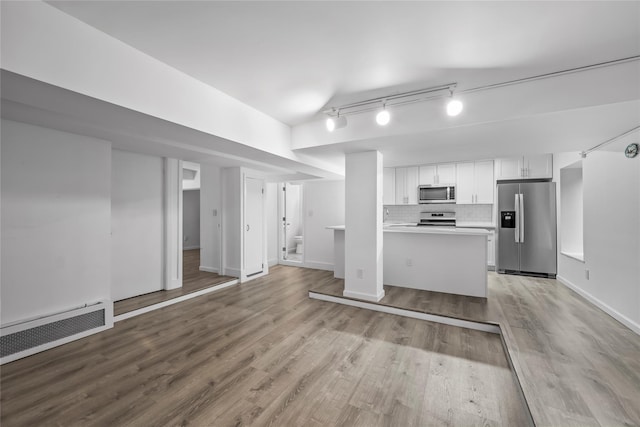 1440 Boston Post Unit 8K, Larchmont, NY 10543 - kitchen with stainless steel appliances, white cabinetry, wood finished floors, tasteful backsplash, and light countertops