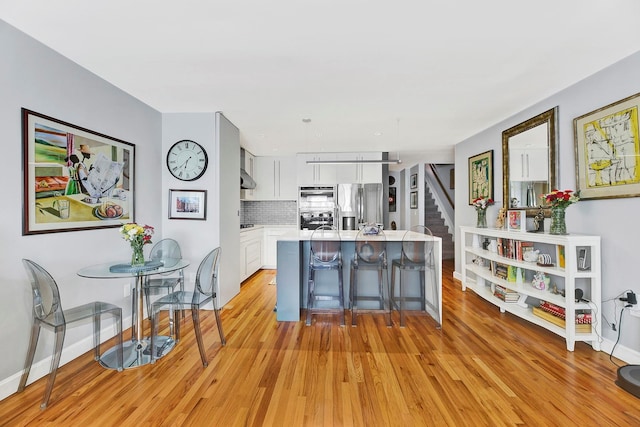 2723 Tilden Ave, Brooklyn, NY 11226 - kitchen featuring stainless steel fridge with ice dispenser, white cabinetry, light wood finished floors, and light countertops