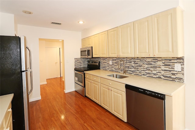 41 Carriage Ct, Jericho, NY 11753 - kitchen with appliances with stainless steel finishes, light countertops, decorative backsplash, wood finished floors, and recessed lighting
