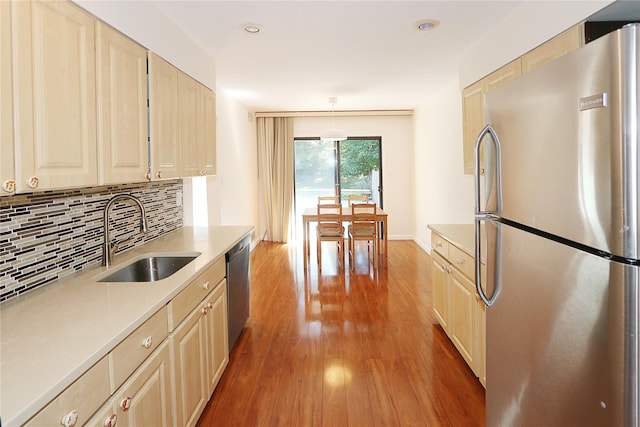 41 Carriage Ct, Jericho, NY 11753 - kitchen featuring stainless steel appliances, wood finished floors, backsplash, light countertops, and light brown cabinetry