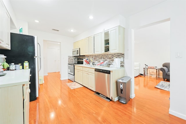 41 Carriage Ct, Jericho, NY 11753 - kitchen with appliances with stainless steel finishes, backsplash, light countertops, light wood finished floors, and recessed lighting