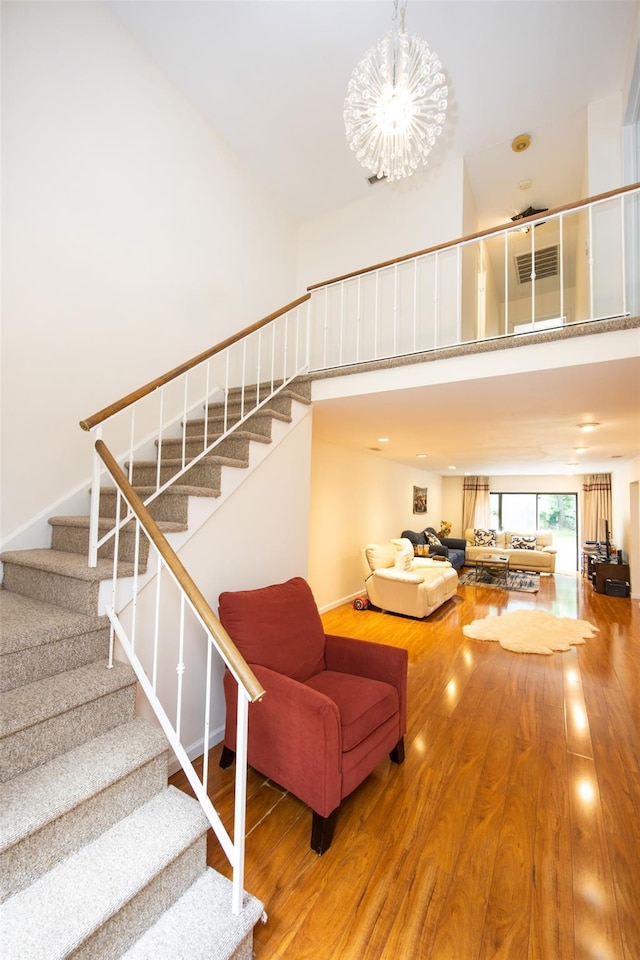 41 Carriage Ct, Jericho, NY 11753 - stairway with a towering ceiling, wood finished floors, and a chandelier